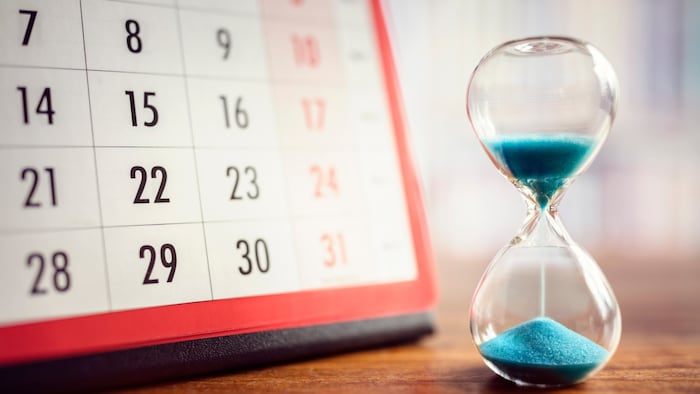 Hour glass and calendar concept for time slipping away for important appointment date, schedule and deadline